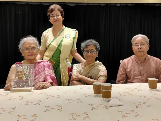 Honourees and hosts seated together at a long table