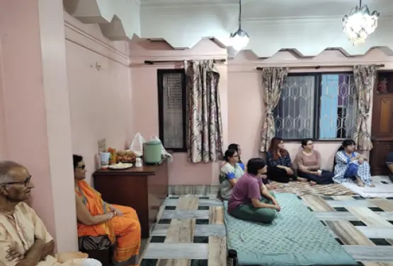 An intimate story circle in a home with listeners on floor mats